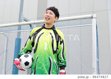 サッカーボールをキャッチするゴールキーパーの男性 96474827