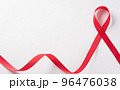 Closeup red ribbon HIV, world AIDS day awareness ribbon on white background. Healthcare and medicine concept. 96476038
