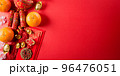 Chinese new year decorations made from red packet, orange and gold ingots or golden lump on a red background. Chinese characters FU in the article refer to fortune good luck, wealth, money flow. 96476051