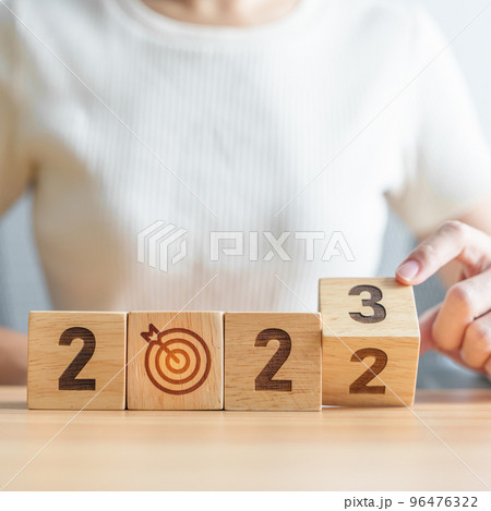 woman hand change 2022 to 2023 block with dartboard icon. Goal, Target, Resolution, strategy, plan, Action, mission, motivation, and New Year start concepts woman hand change 2022 to 2023 block with dartboard icon. Goal, Target, Resolution, strategy, plan, Action, mission, motivation, and New Year start concepts 96476322