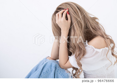膝を抱えて座り込む女性　worried woman 96476666