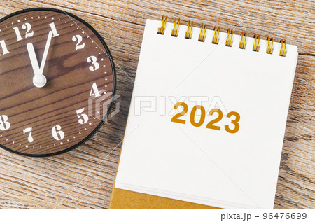 The 2023 Desk calender with clock on wooden background. 96476699