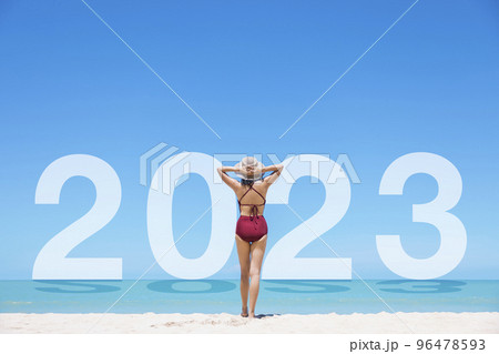 Young women in bikini and straw hat stand on tropical beach enjoying looking view of beach ocean on hot summer day. Blue sea in 2023 background. Khao Lak, Phang Nga, Thailand. Summer vacation concept. 96478593