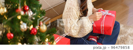 Christmas celebration concept, Young asian woman sitting on the floor and opening christmas gift 96479858