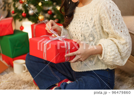 Christmas celebration concept, Young asian woman sitting on the floor and opening christmas gift 96479860