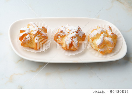 Homemade profiteroles with powdered sugar on white plate 96480812