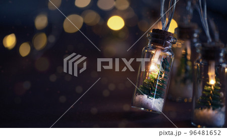 Creative Christmas garland lights with bokeh. Christmas tree in a glass jar with snow. Christmas greeting card. 96481652