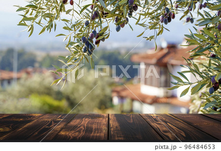 Wooden table on the background of olive trees and a farm garden. Summer rustic food product background. Eco, natural, farming concept 96484653