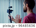 A young blogger records a video with himself on his smartphone in his room studio 96485636