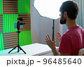 A young blogger records a video with himself on his smartphone in his room studio 96485640