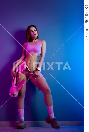 sexy girl in pink short clothes with pink rabbit mask on neon background 96486534