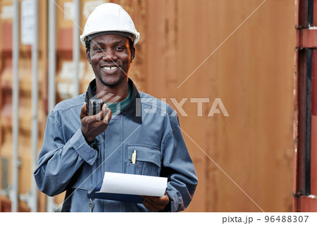 Black man smiling at camera while working at shipping docks 96488307