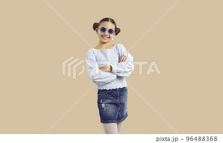 Happy pretty girl in trendy casual outfit and sunglasses posing on beige background 96488368