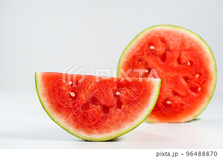 Red watermelon slice close-up on white background, space for text. Half of a ripe scarlet watermelon fruit with red juicy flesh and seeds turned sideways in profile, text space above. 96488870