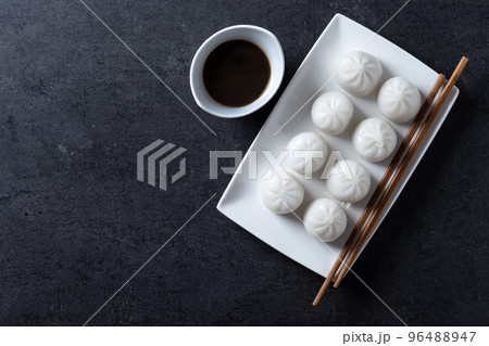 Steamed dumplings on black slate background 96488947