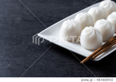 Steamed dumplings on black slate background Steamed dumplings on black slate background 96488950