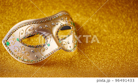 Festive, colorful Mardi Gras or carnivale mask and beads on golden background. Venetian masks. Party invitation, greeting card, venetian carnivale celebration concept. Festive, colorful Mardi Gras or carnivale mask and beads on golden background. Venetian masks. Party invitation, greeting card, venetian carnivale celebration concept. 96491433