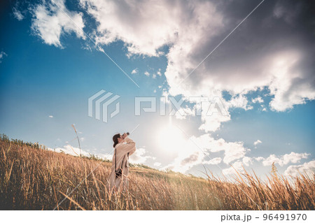 青空と秋の草原と女性 96491970