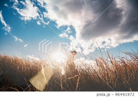 青空と秋の草原と女性 96491972