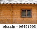 Window of an ecological wooden house with a snowy roof 96491993