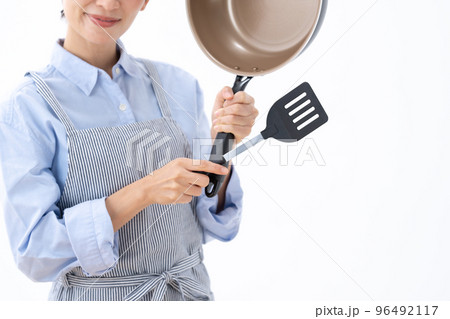 フライパンとフライパン返しを持つ女性 96492117