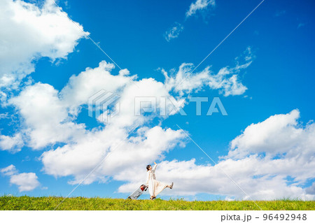 キャリーバックとたくさんの荷物を持って田舎を訪れた女性 96492948