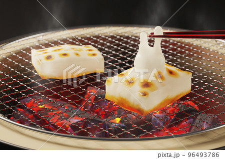 箸先で摘まれたうさぎの形に膨らんだ切り餅 / 卯年・年賀状・新春のグラフィックイメージ 96493786