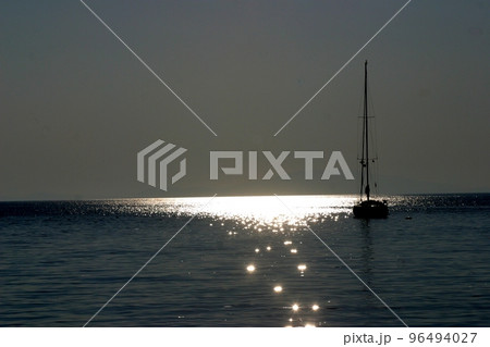 Boat sailing away at sundown 96494027