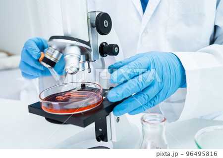 Asian scientist biochemist or microbiologist working research with a microscope in laboratory. For protect outbreak Coronavirus Covid19, bacteria and germs. Asian scientist biochemist or microbiologist working research with a microscope in laboratory. For protect outbreak Coronavirus Covid19, bacteria and germs. 96495816