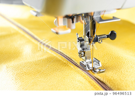 Modern sewing machine and yellow fabric. Sewing process, handmade, hobby, DIY, business, repair 96496513