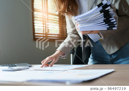financial, Planning, Marketing and Accounting, portrait of Asian employee checking financial statements using documents and computer laptop at work. financial, Planning, Marketing and Accounting, portrait of Asian employee checking financial statements using documents and computer laptop at work. 96497219