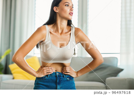 Abdominal exercises concpet. Slim lady doing belly vacuum flexing abs muscles during fitness workout, copy space Abdominal exercises concpet. Slim lady doing belly vacuum flexing abs muscles during fitness workout, copy space 96497618