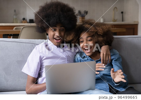 Surprised African teenagers couple staring at laptop screen 96499665