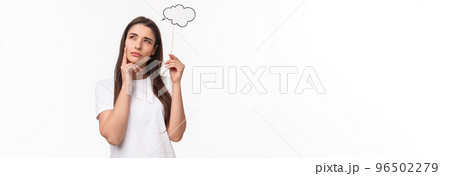 Entertainment, fun and holidays concept. Portrait of thoughtful and creative young woman searching inspiration, holding thinking cloud near head, squinting and look focused up, pondering 96502279