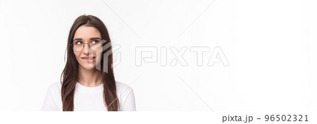 Close-up portrait of sassy and cute young brunette girl, biting lip tempting do something, having plan, look up thoughtful, standing white background, imaging or daydreaming Close-up portrait of sassy and cute young brunette girl, biting lip tempting do something, having plan, look up thoughtful, standing white background, imaging or daydreaming 96502321