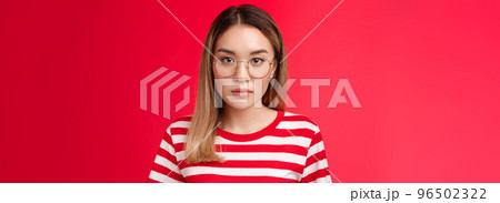 Close-up serious-looking focused smart asian young female student carefully listen lecture look camera concentrated wear prescribed glasses stand striped t-shirt red background Close-up serious-looking focused smart asian young female student carefully listen lecture look camera concentrated wear prescribed glasses stand striped t-shirt red background 96502322