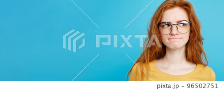 Close up Portrait young beautiful attractive redhair girl with eyeglass worry with something. Blue Pastel Background. Copy space. Close up Portrait young beautiful attractive redhair girl with eyeglass worry with something. Blue Pastel Background. Copy space. 96502751