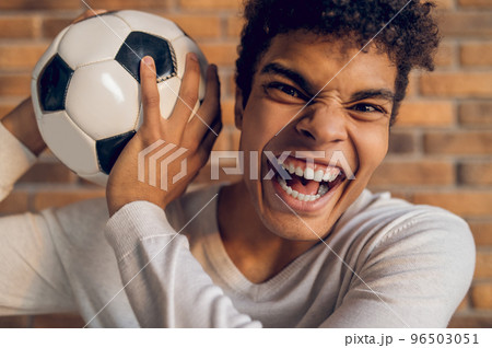 Aggressive footballer posing for the camera indoors 96503051