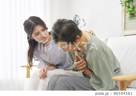 家で胸が痛む高齢者女性 96504561