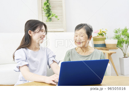 家でパソコンを使うを使う孫と祖母 96505016