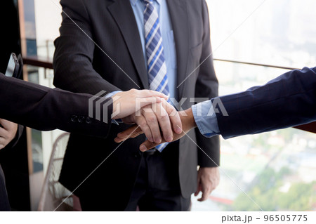Closeup hands of group of business team harmony with man and woman and partner joining hands stack. 96505775