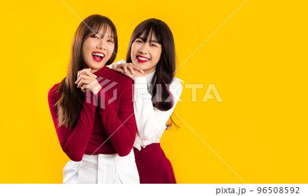 Young asian lesbian lgbt couple women in red and white Christmas theme yellow background. 96508592
