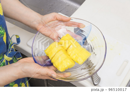 【切り終わったパイナップルをお皿に盛っていく】 96510017