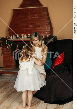 Adorable mom and daughter dress up in beautiful dresses for Christmas. Preparation for the holiday, New Year, Christmas, family holiday 96510478