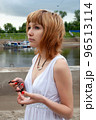 Red hair woman relaxing on river bank 96513114