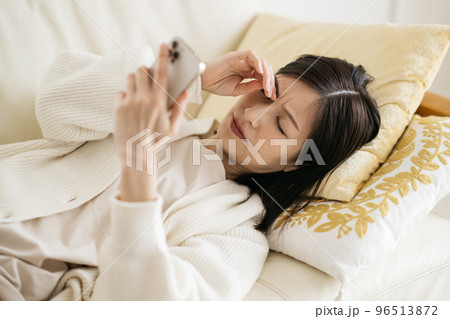ソファーでスマホを見る女性 ソファーでスマホを見る女性 96513872