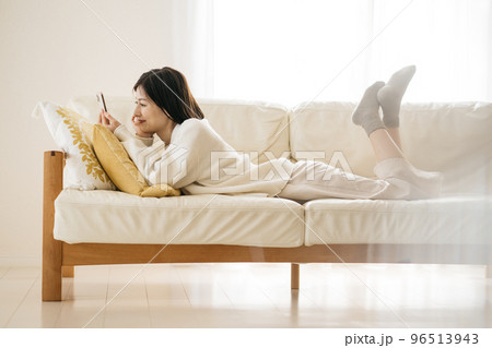 ソファーでスマホを見る女性 96513943