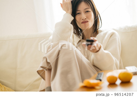 部屋でくつろぐ主婦・テレビを見る女性 96514207