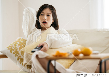 部屋でくつろぐ主婦・テレビを見る女性 96514336
