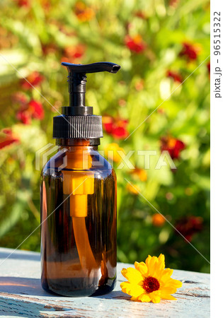Brown glass bottle with pump of cosmetic products on bright floral background. Natural Organic Spa Cosmetic Beauty Concept Mockup Front view 96515322